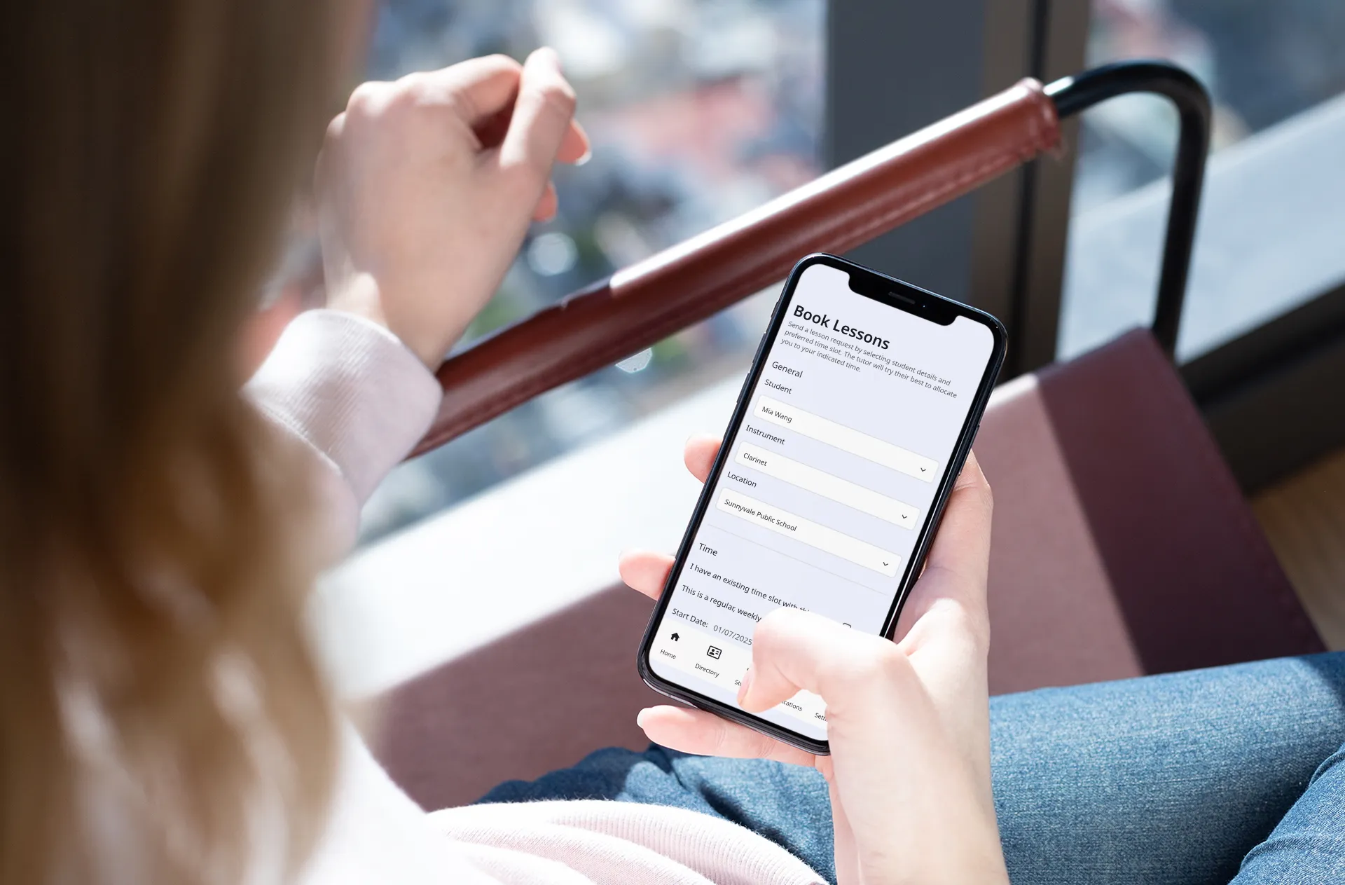A woman on a bus holding an iPhone, looking at a screen on Pocket Tutor that says Book Lessons.